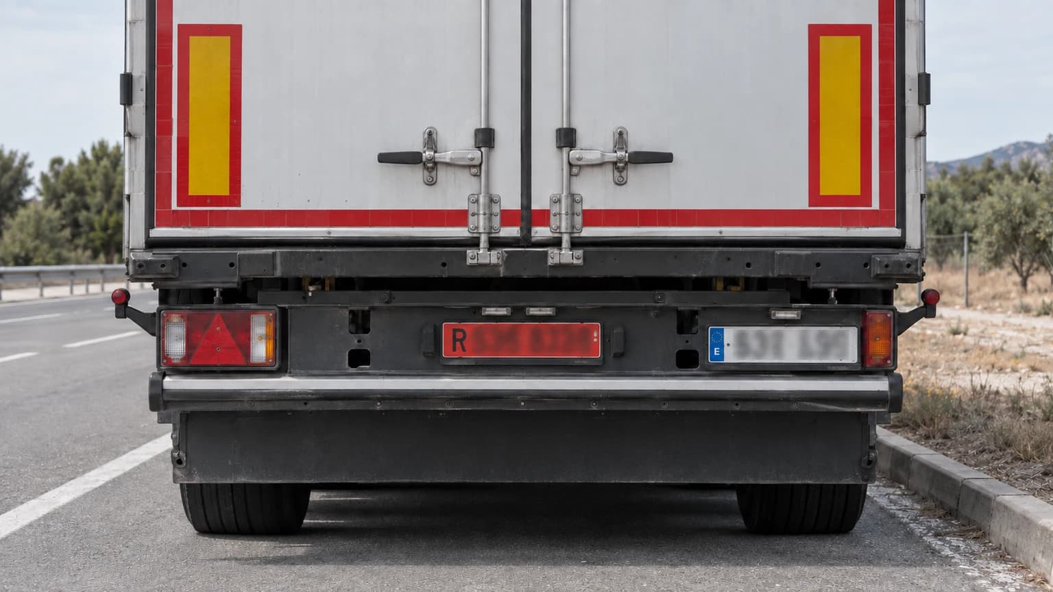 A non-light trailer registered in Spain carries its own rear number plate and another bearing the towing vehicle’s registration, as in the photograph. Is this correct?