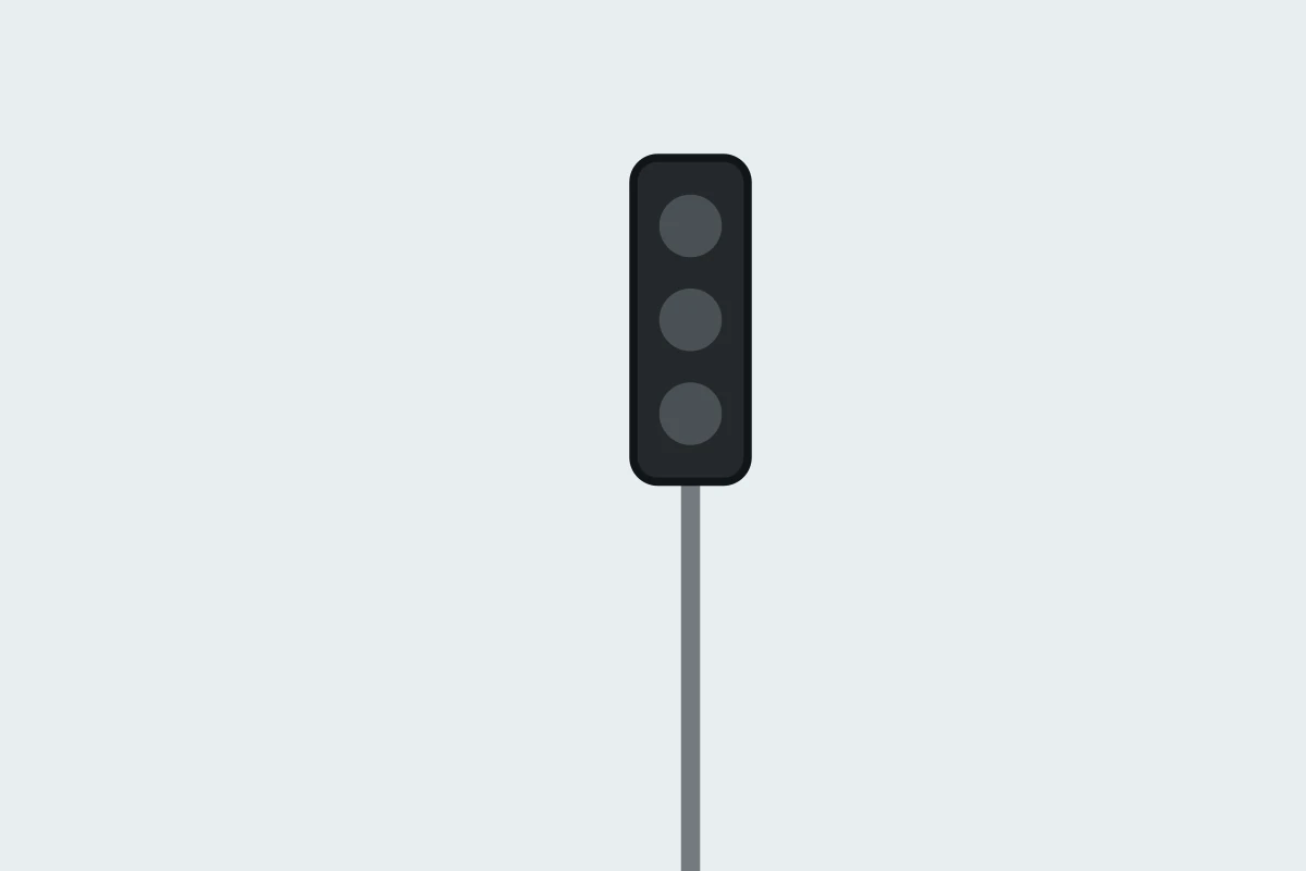 A circular traffic light before a junction shows a steady red light, with no green arrow authorising your movement. Where must you stop?